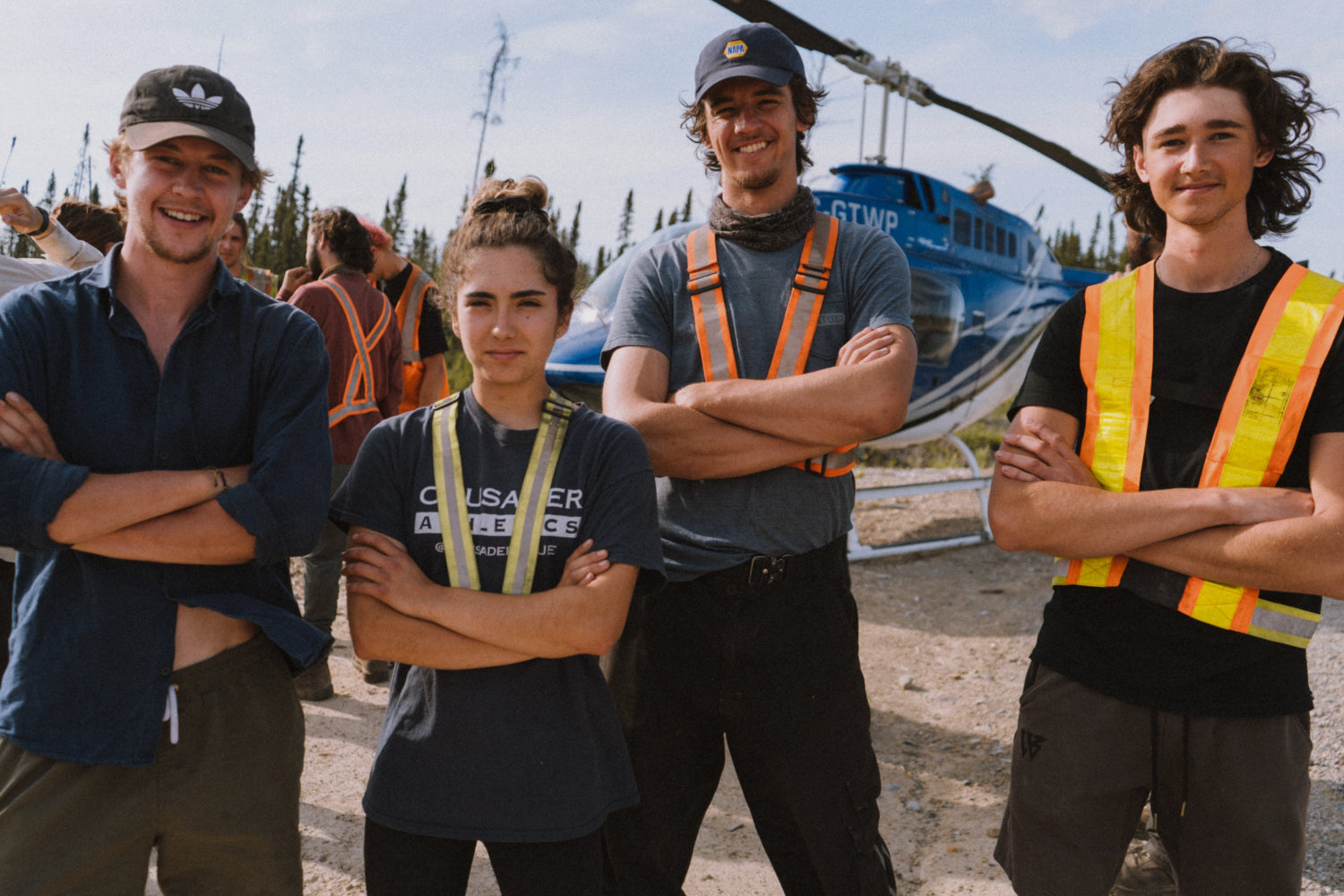 Integrity Reforestation crew standing in front of a helicopter with safety vests and hats